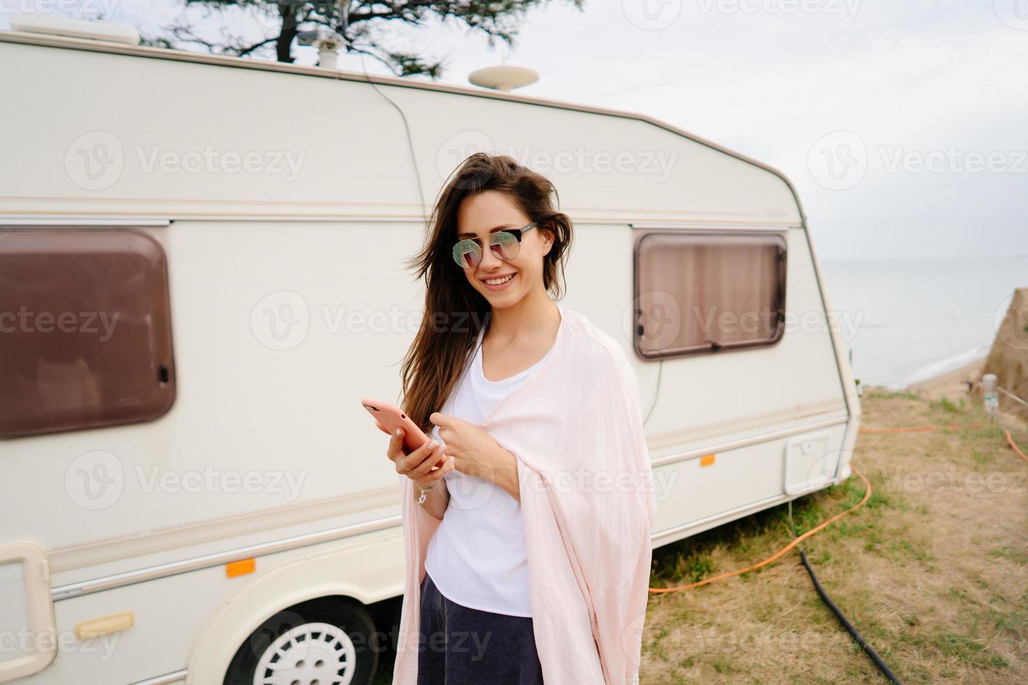 Beautiful, young girl posing on a wild beach sailor at the van photo