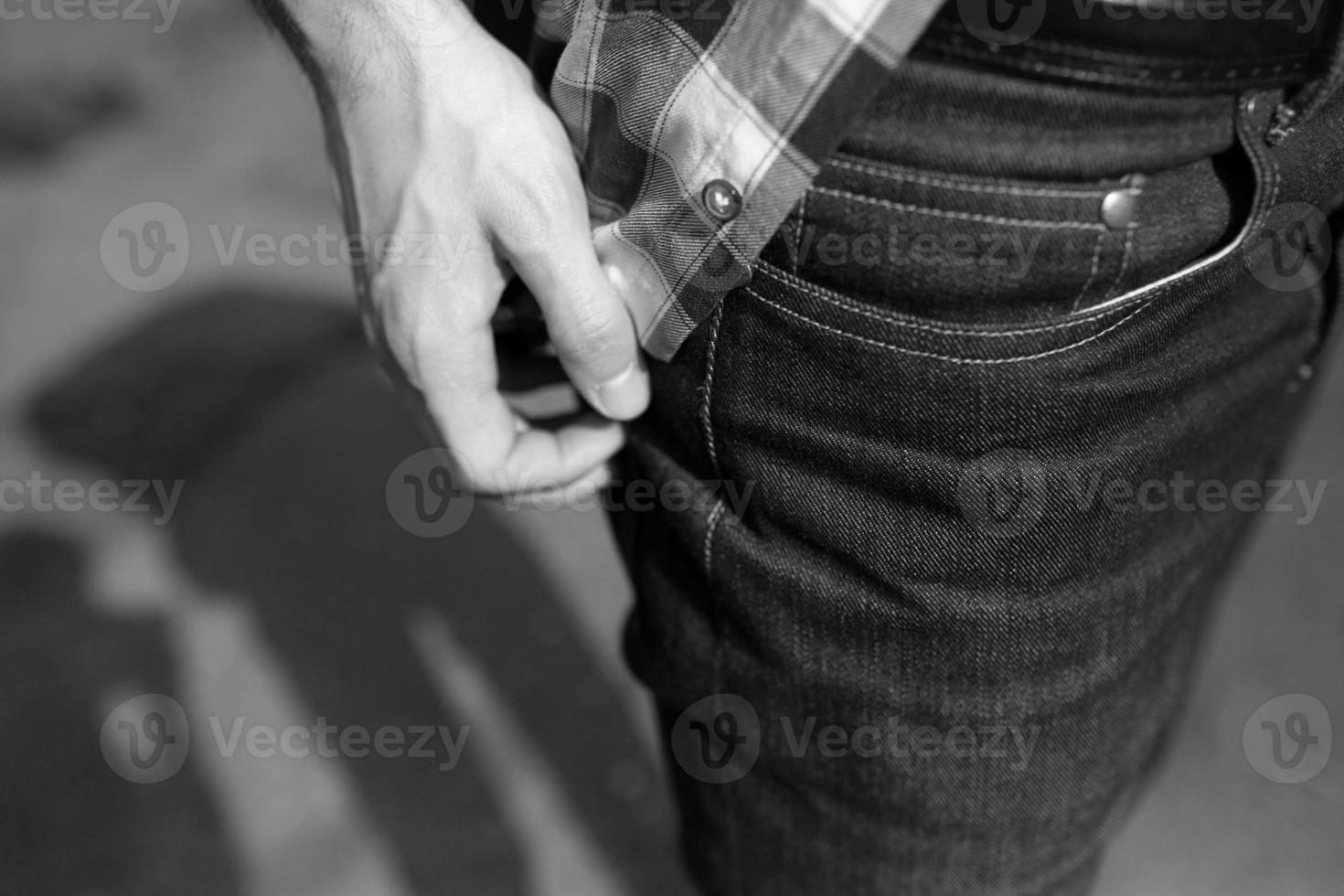 A man adjusts his shirt over jeans background photo