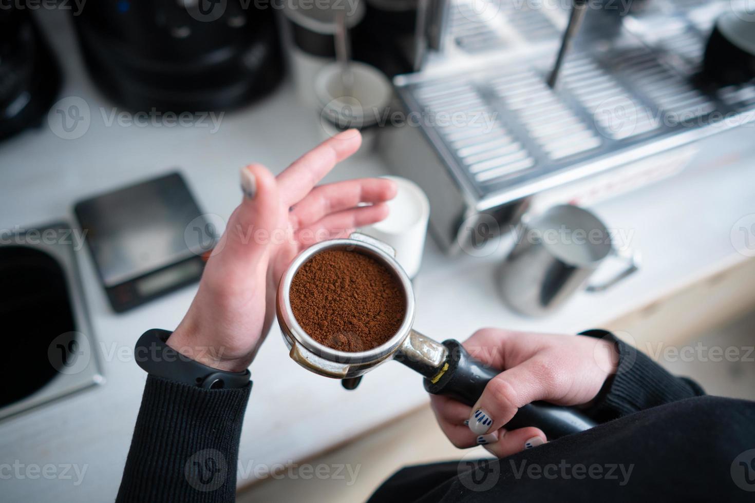 Barista holding portafilter with ground coffee photo