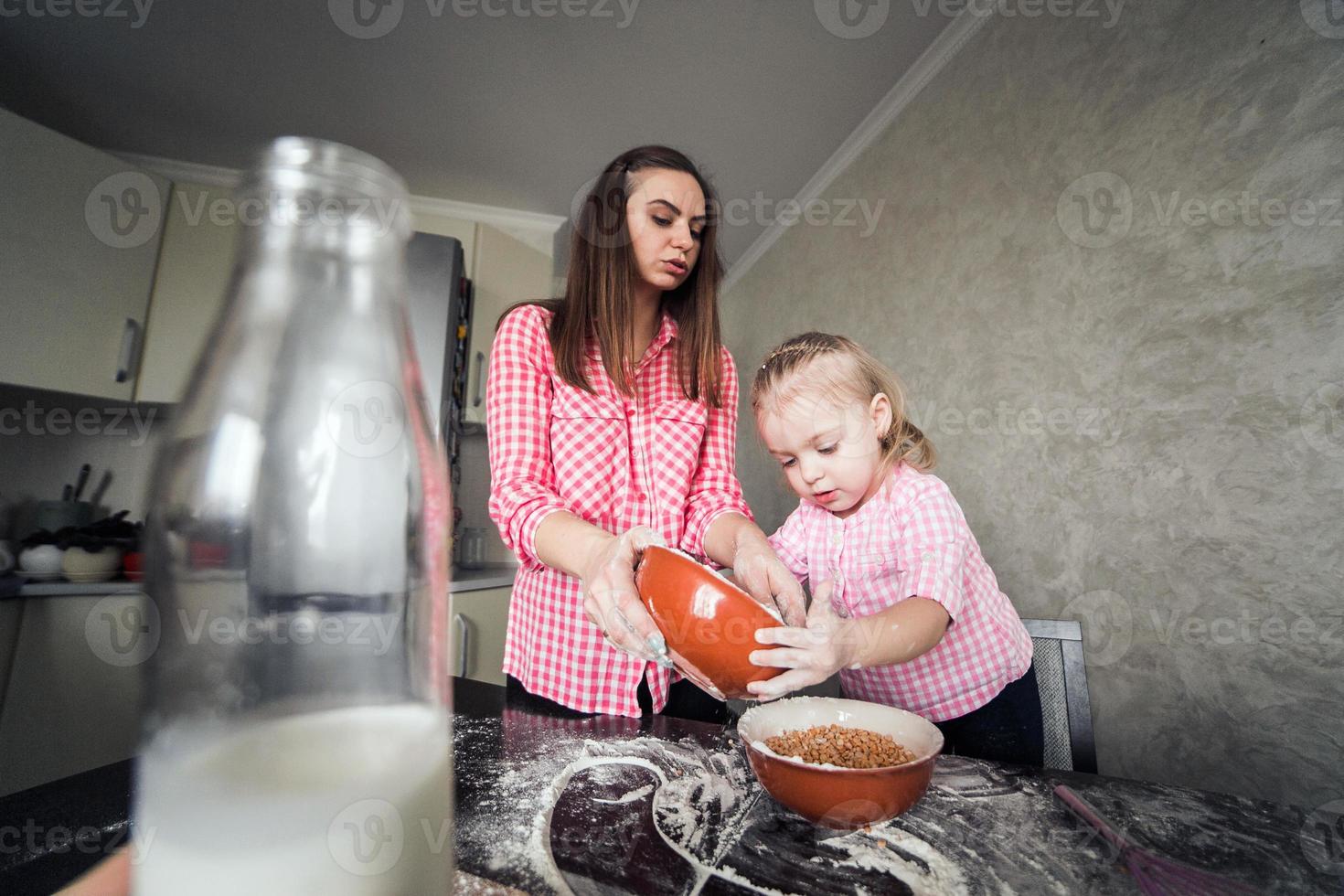 mamá e hija juntas en la cocina foto