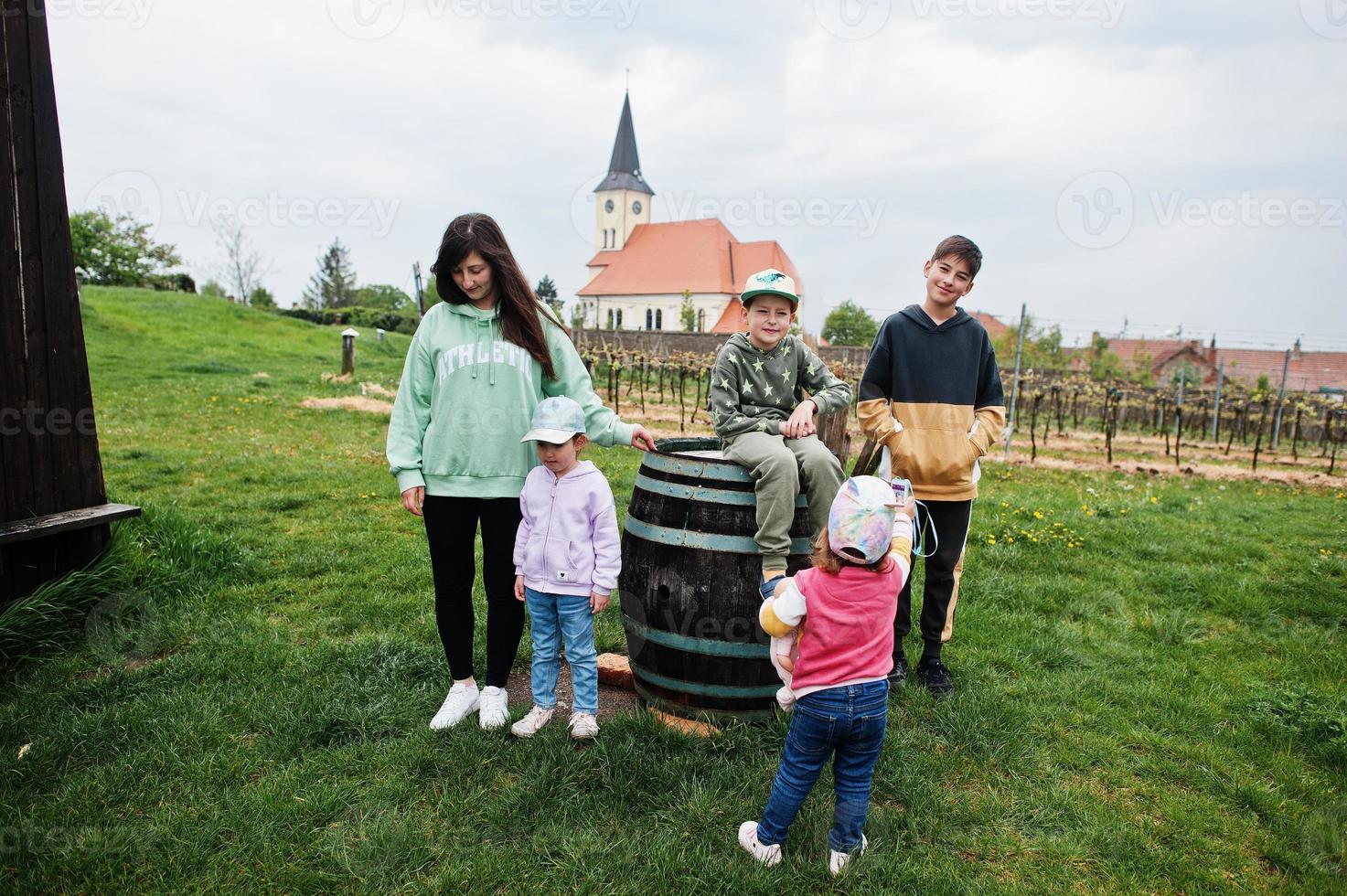 Mother with kids walking near traditional wine cellars outdoor at Vrbice, Czech Republic. photo
