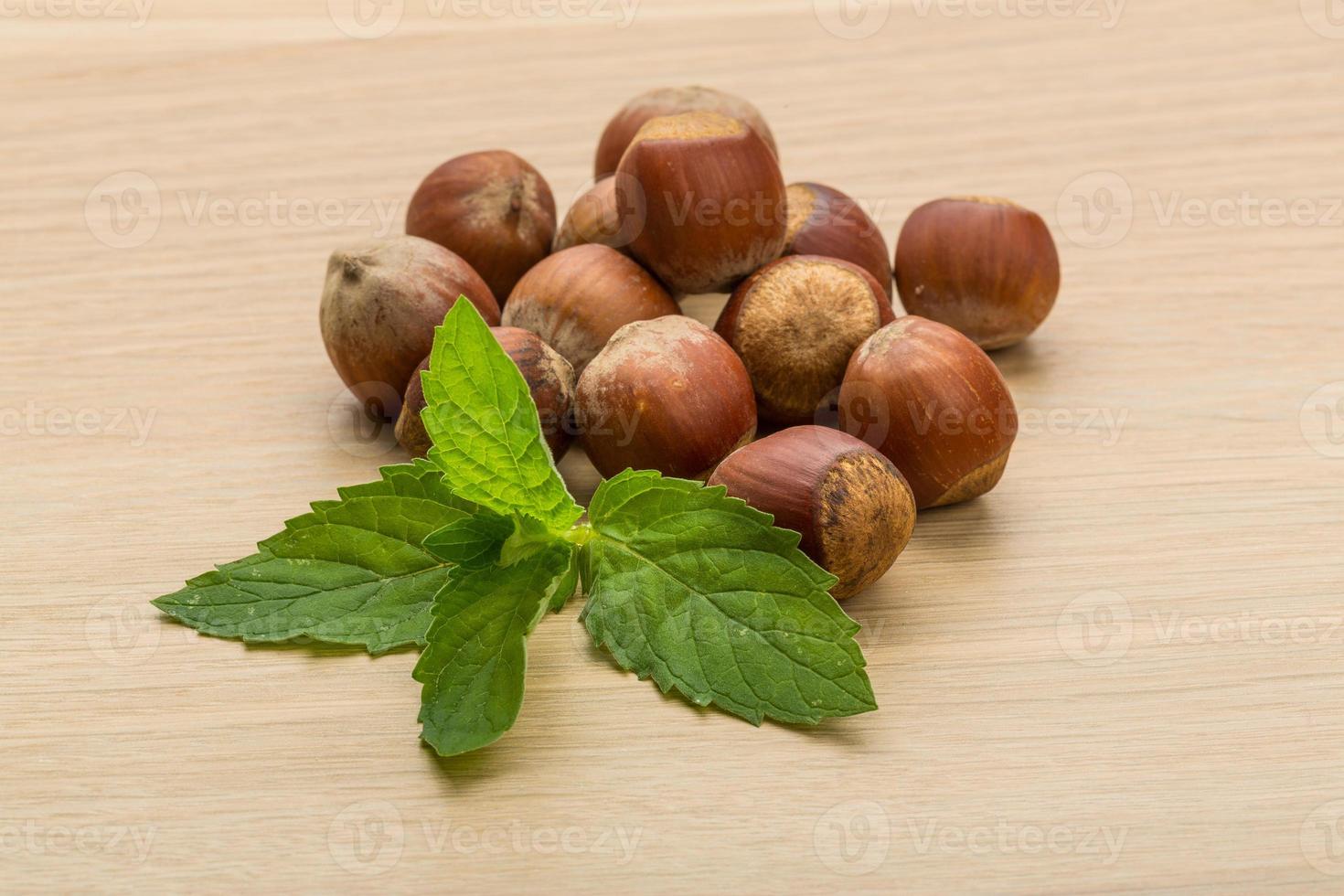 Hazelnut heap on wooden background photo