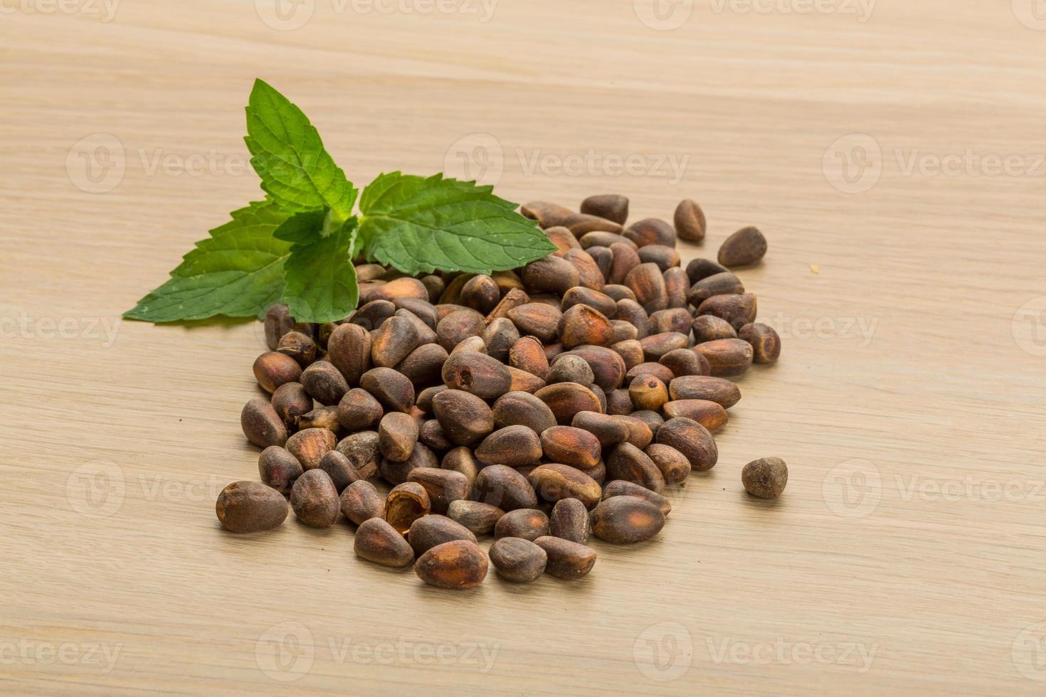 Cedar nuts on wooden background photo