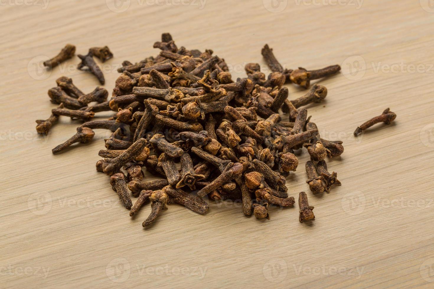 Clove seeds on wooden background photo