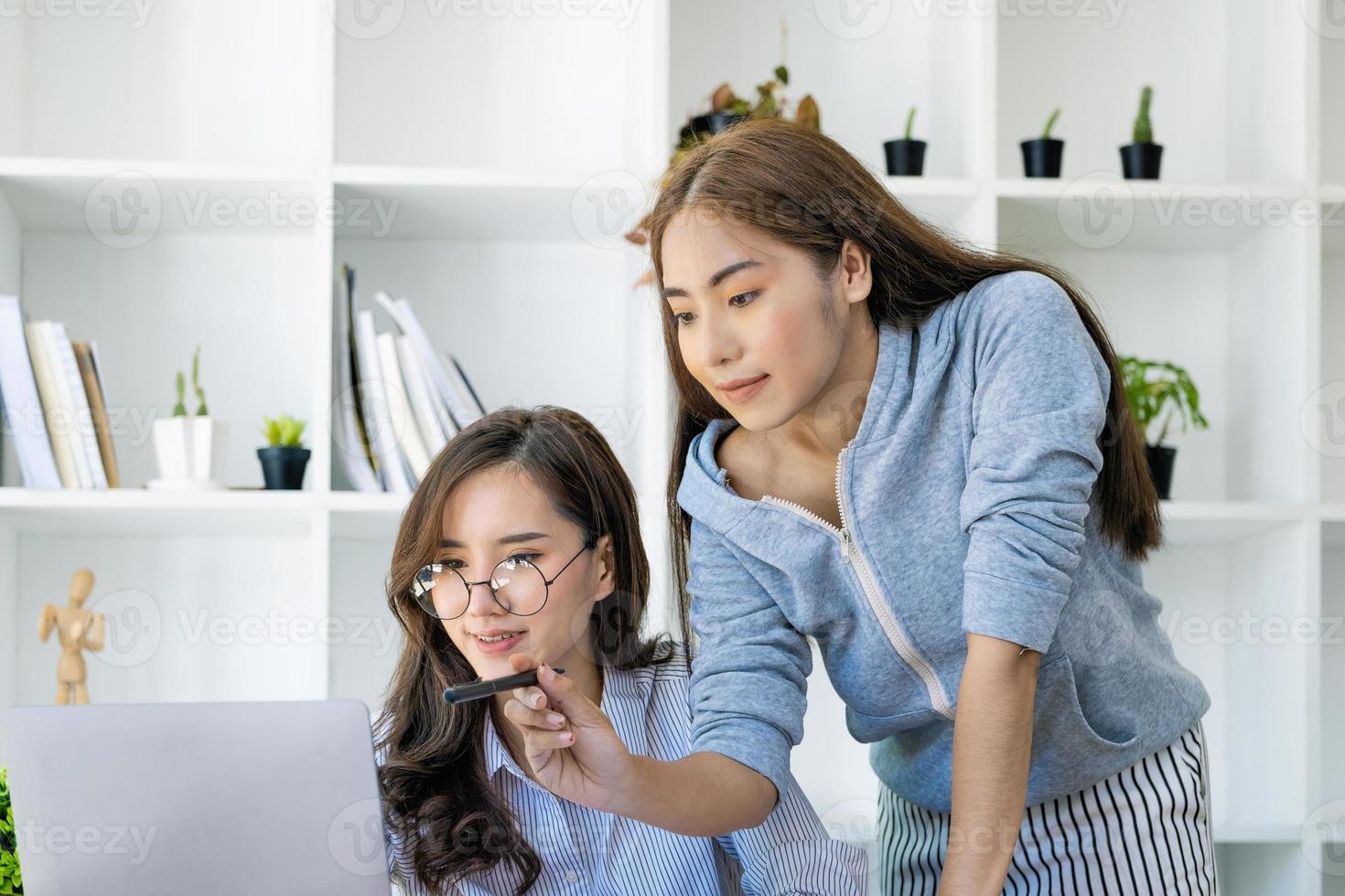 A businesswoman and a colleague are using computers to calculate the last quarter of the year's income budget to plan financial investments for the next year. photo