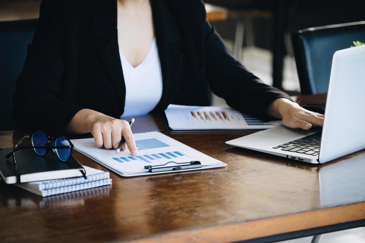 Investment concepts, businesswomen use document and computers to analyze stock markets, quantitative data collection, financial statement analysis, profitability through internet technology. photo