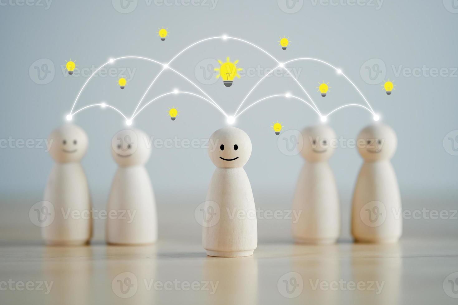 Idea. Teamwork. Happy wooden person figure standing with team and they have light bulb symbol for create and share  idea for team. Social connections. Leader and leadership, coordination. Creativity. photo