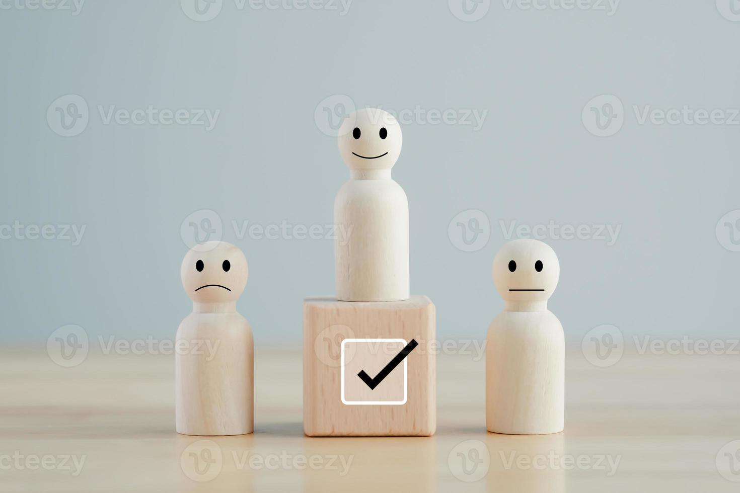 Select happy face figure on top of wooden blocks. Evaluation, Performance Appraisal, Skill, Success, Expert, Leadership. Human Resources management choosing positive attitude to team leader. photo