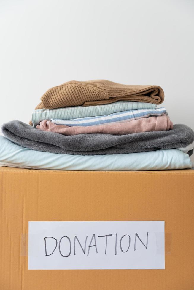 Clothing donation, Sharing, Hope concept. Used clothes on the carton donation box preparing to others photo