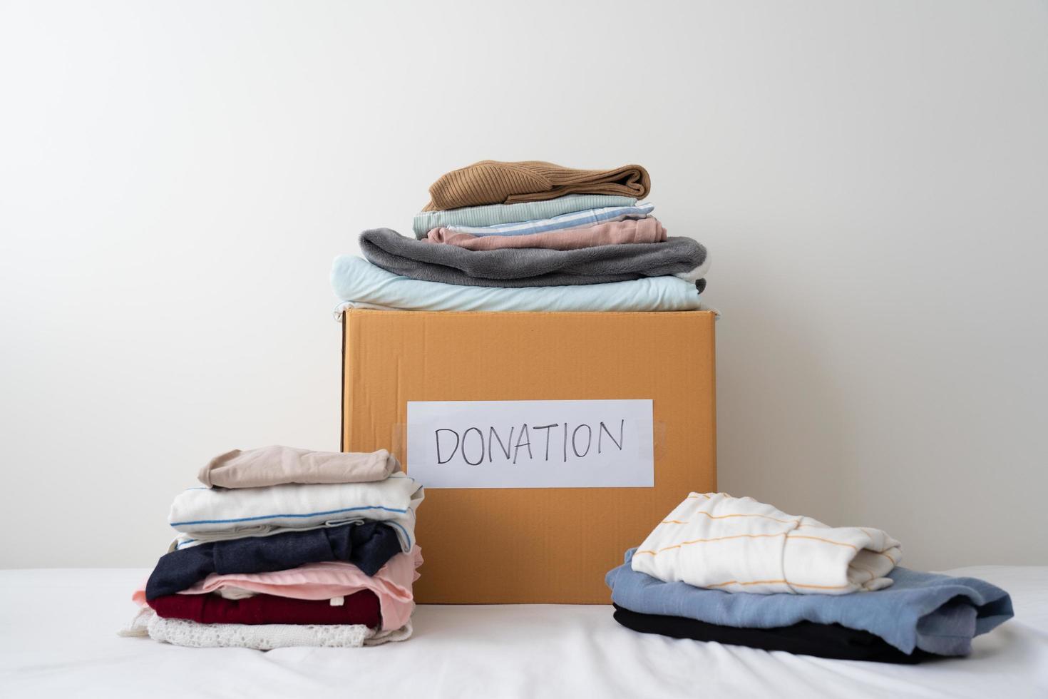 Clothing donation, Sharing, Hope concept. Used clothes on the carton donation box preparing to others photo