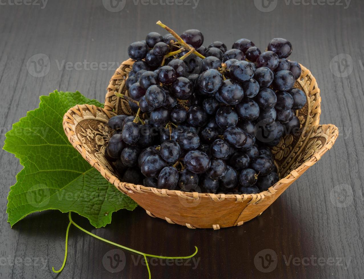 Grape in a basket on wooden background photo