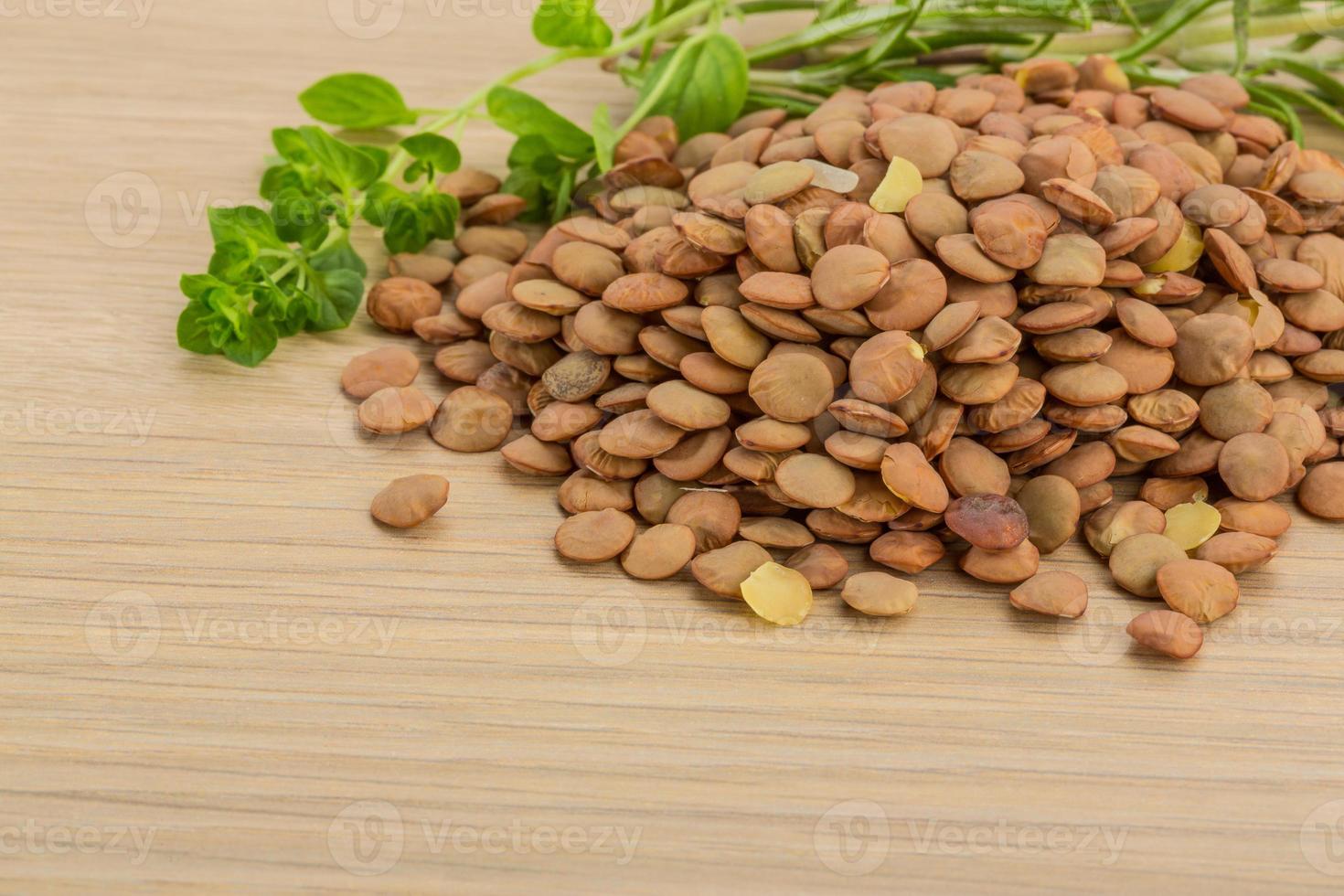 Raw lentils on wooden background photo