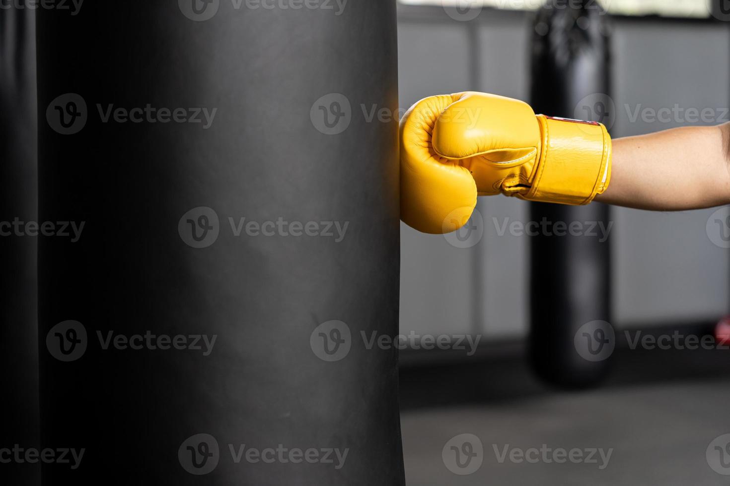 punching bag wearing yellow boxing gloves. copy space photo