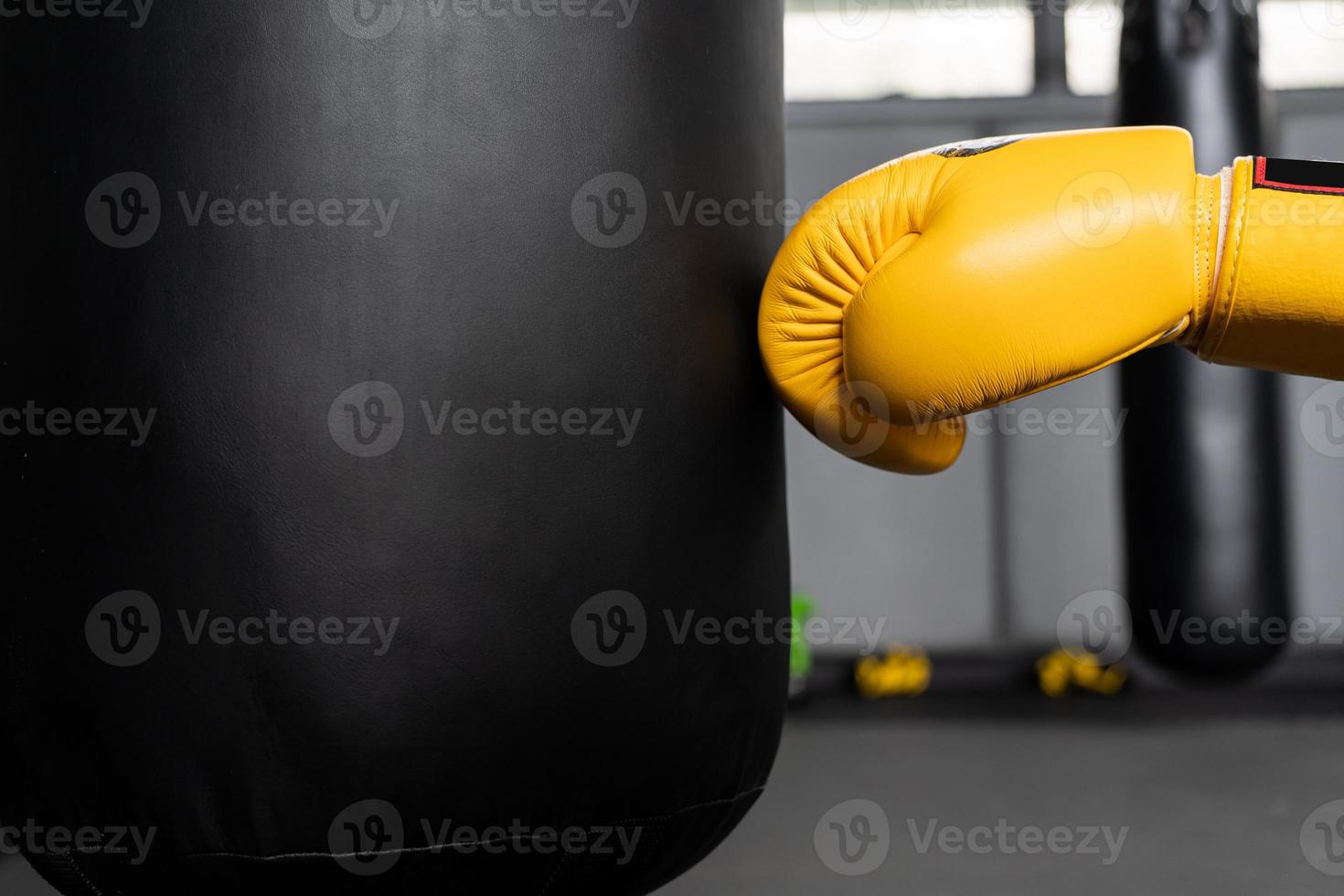 punching bag wearing yellow boxing gloves. copy space photo