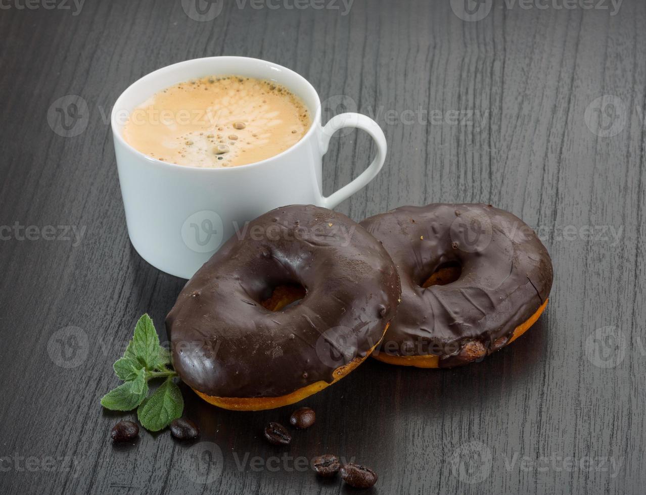 Coffee with Chocolate donuts on wooden background photo