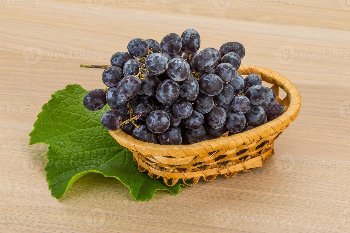 Grape in a basket on wooden background photo