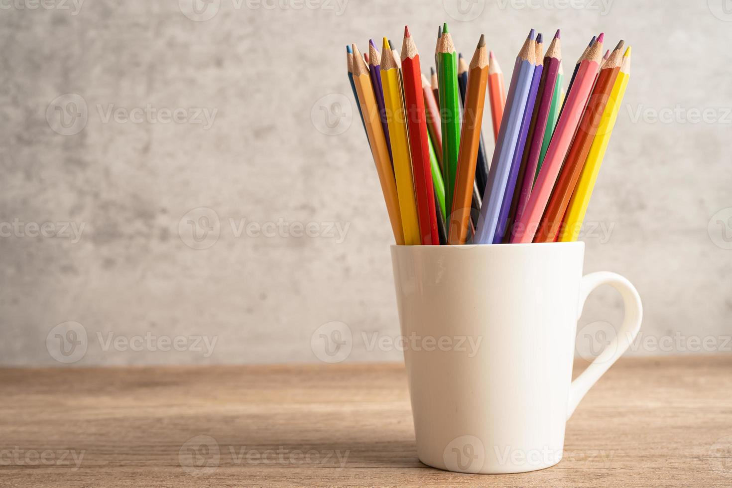 lápices de colores en taza blanca con espacio para copiar, aprendiendo el concepto de educación universitaria. foto