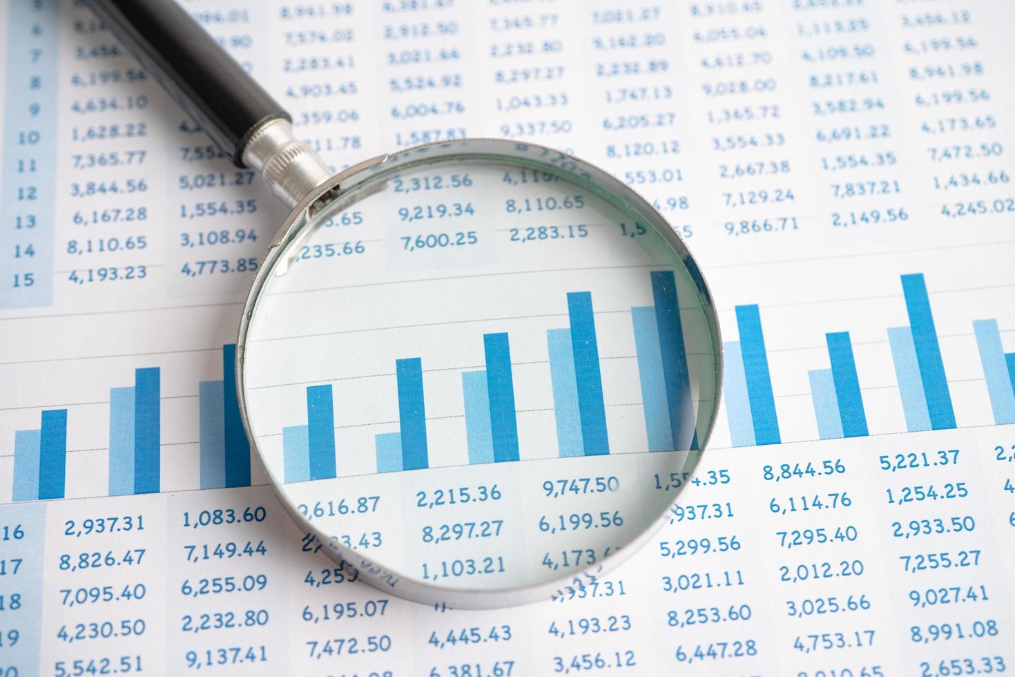 Magnifying glass on chart graph spreadsheet paper. Financial development, Banking Account, Statistics, economy, Stock exchange trading, Business office company meeting concept. photo