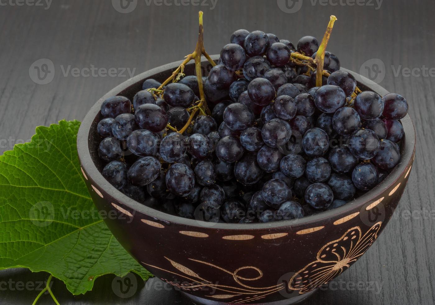 Grape in a bowl on wooden background photo