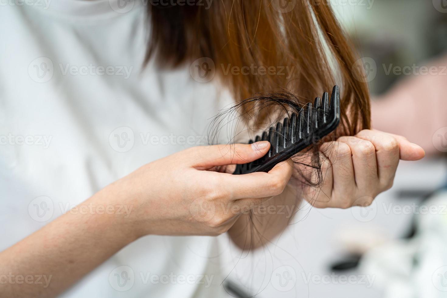 Asian woman have problem with long hair loss attach to comb brush. photo