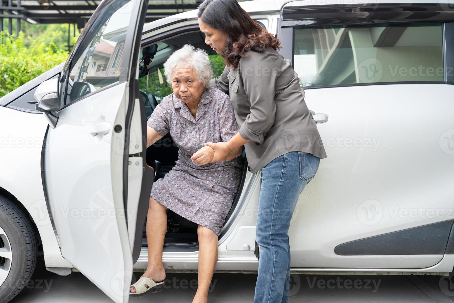 Help and support asian senior or elderly old lady woman patient sitting on wheelchair prepare get to her car, healthy strong medical concept. photo
