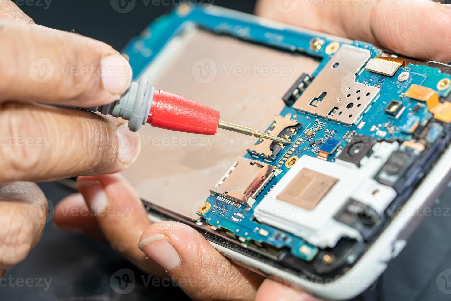 Technician repairing inside of mobile phone by soldering iron. Integrated Circuit. the concept of data, hardware, technology. photo