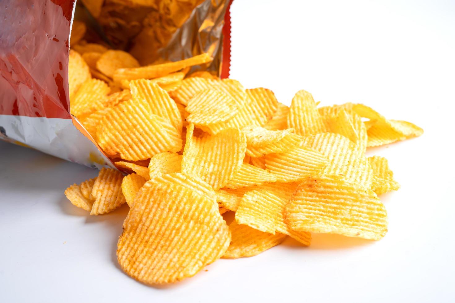 Potato chips, delicious BBQ seasoning spicy for crips, thin slice deep fried snack fast food in open bag. photo