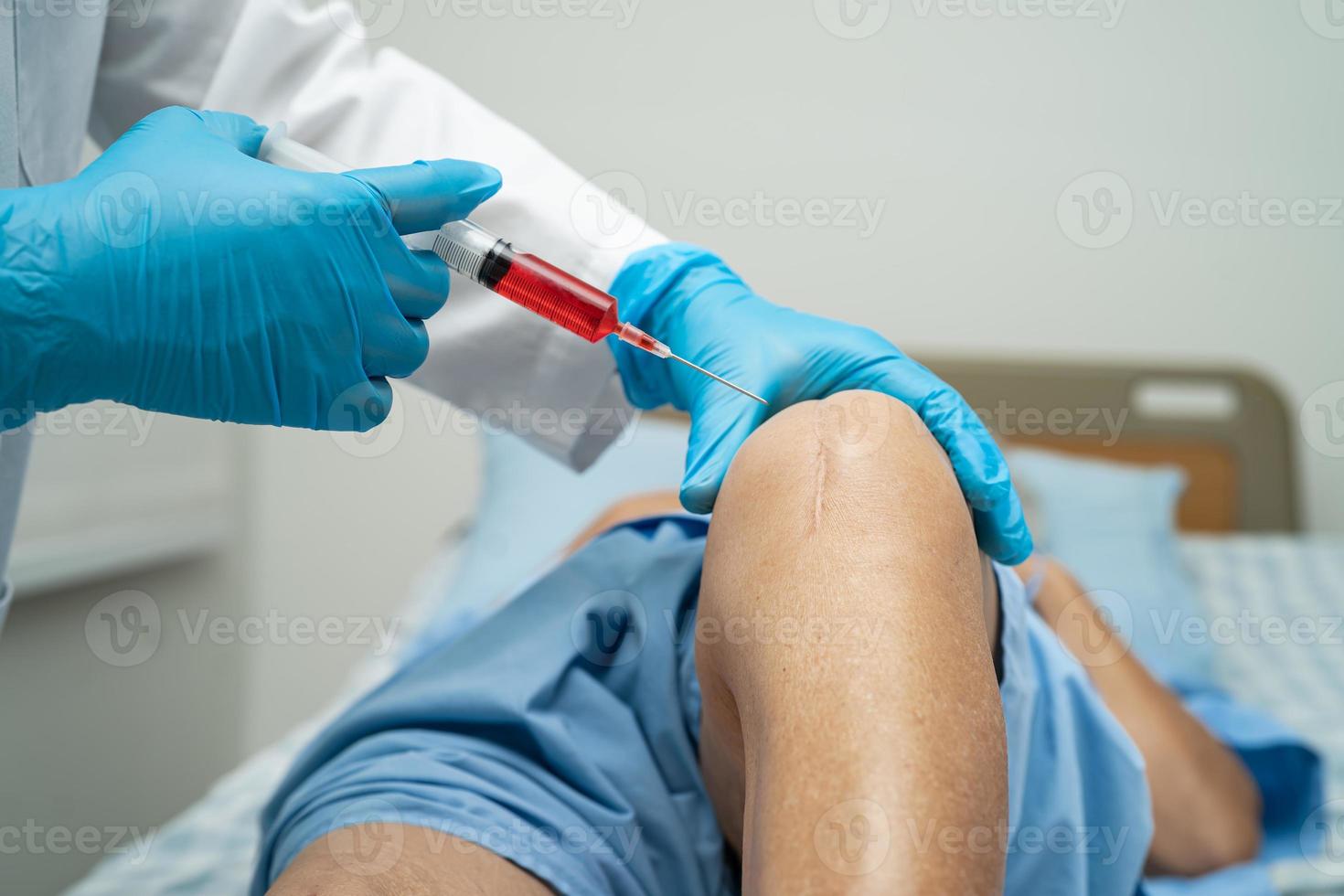 Asian doctor inject Hyaluronic acid platelet rich plasma into the knee of senior woman to walk without pain. photo