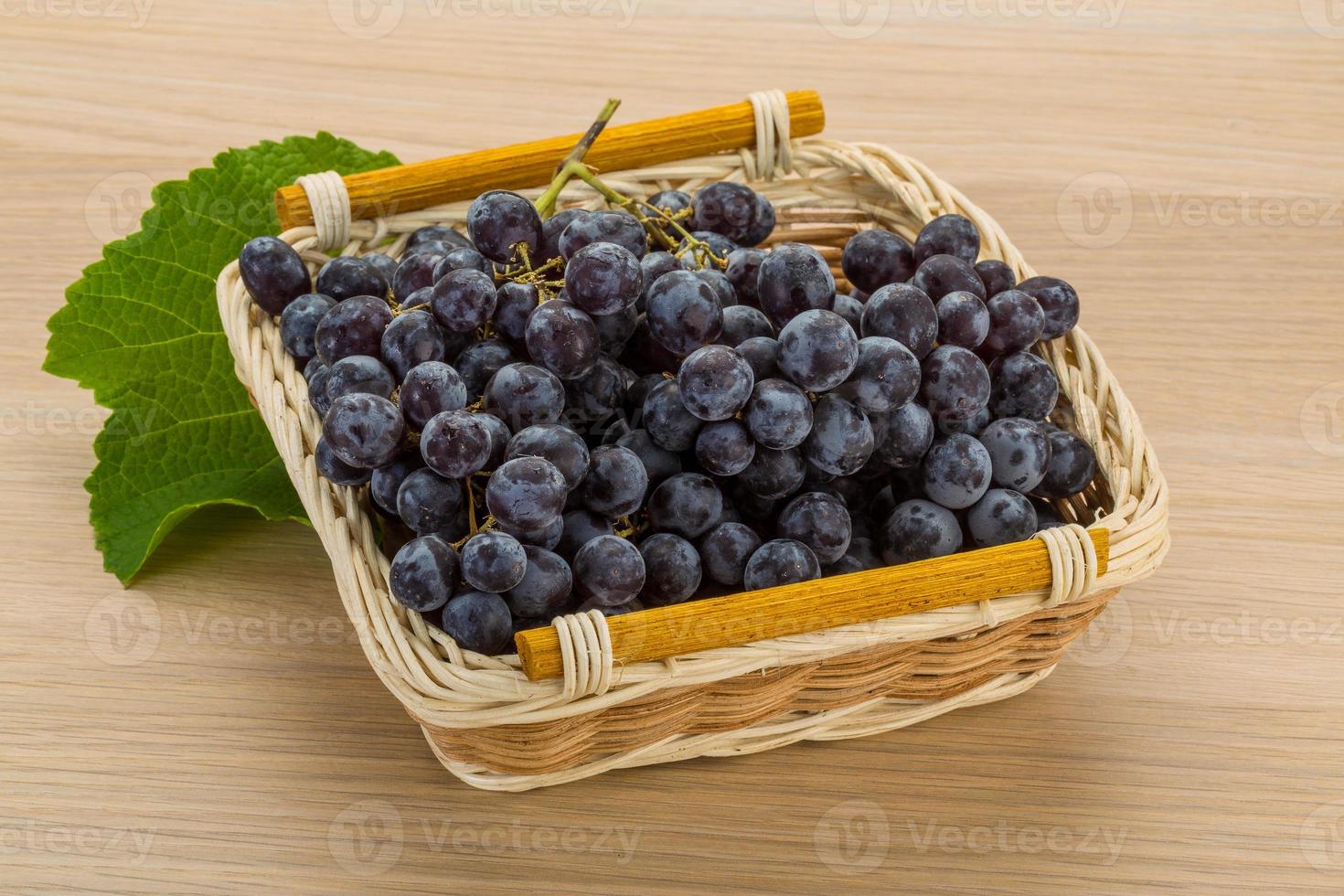Grape in a basket on wooden background photo