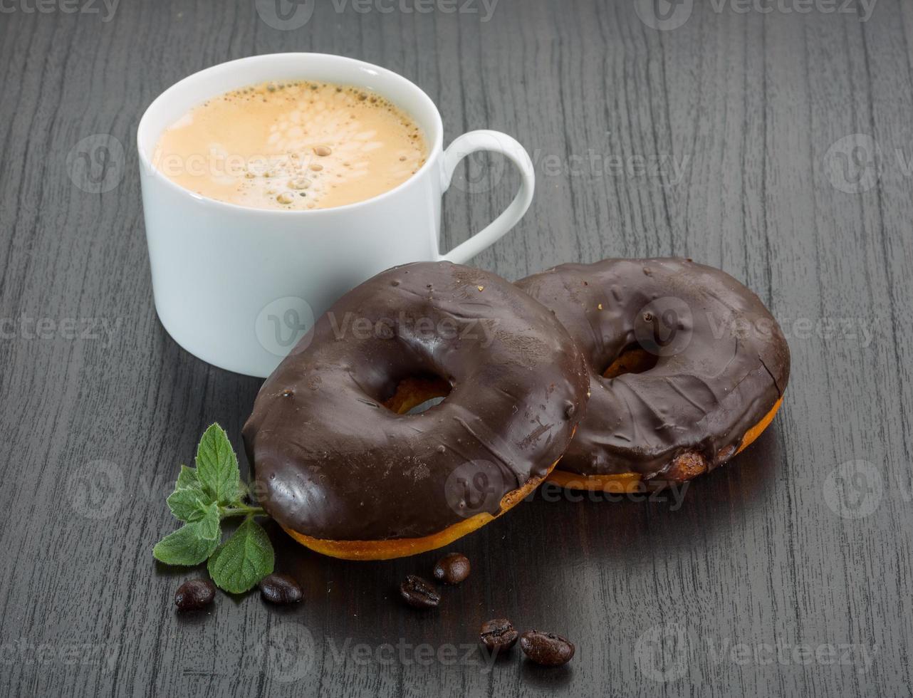 Coffee with Chocolate donuts on wooden background photo