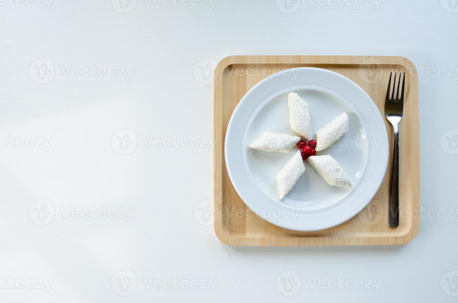 lazy dumplings on a plate, on a wooden tray with a fork. Light background photo