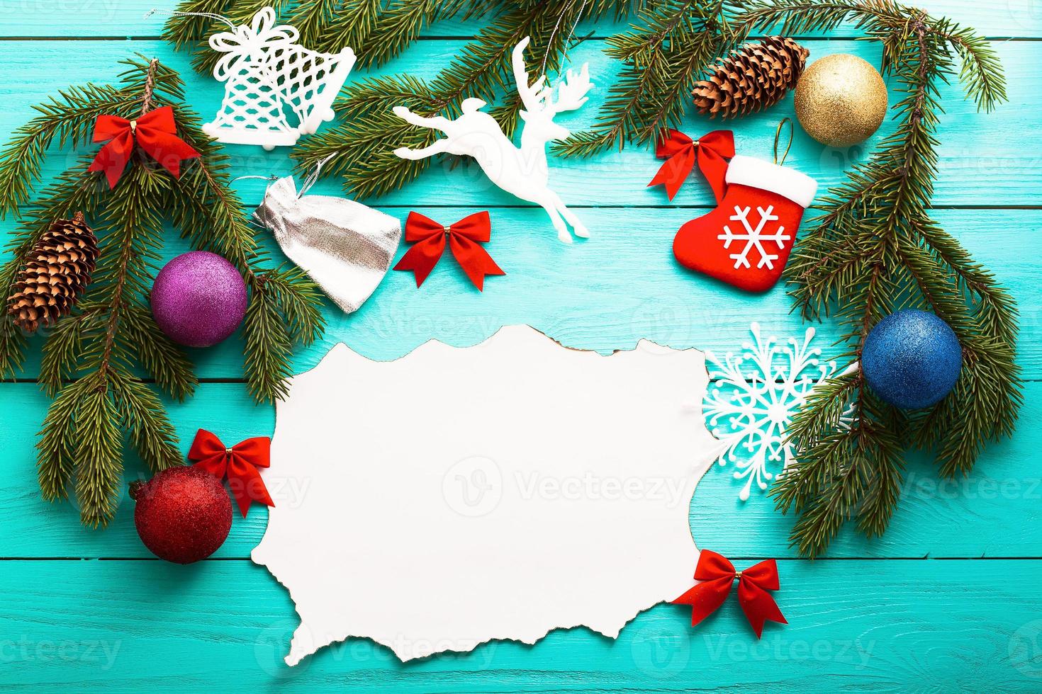 Christmas card with frame of winter accessories on blue wooden background.Top view and selective focus photo