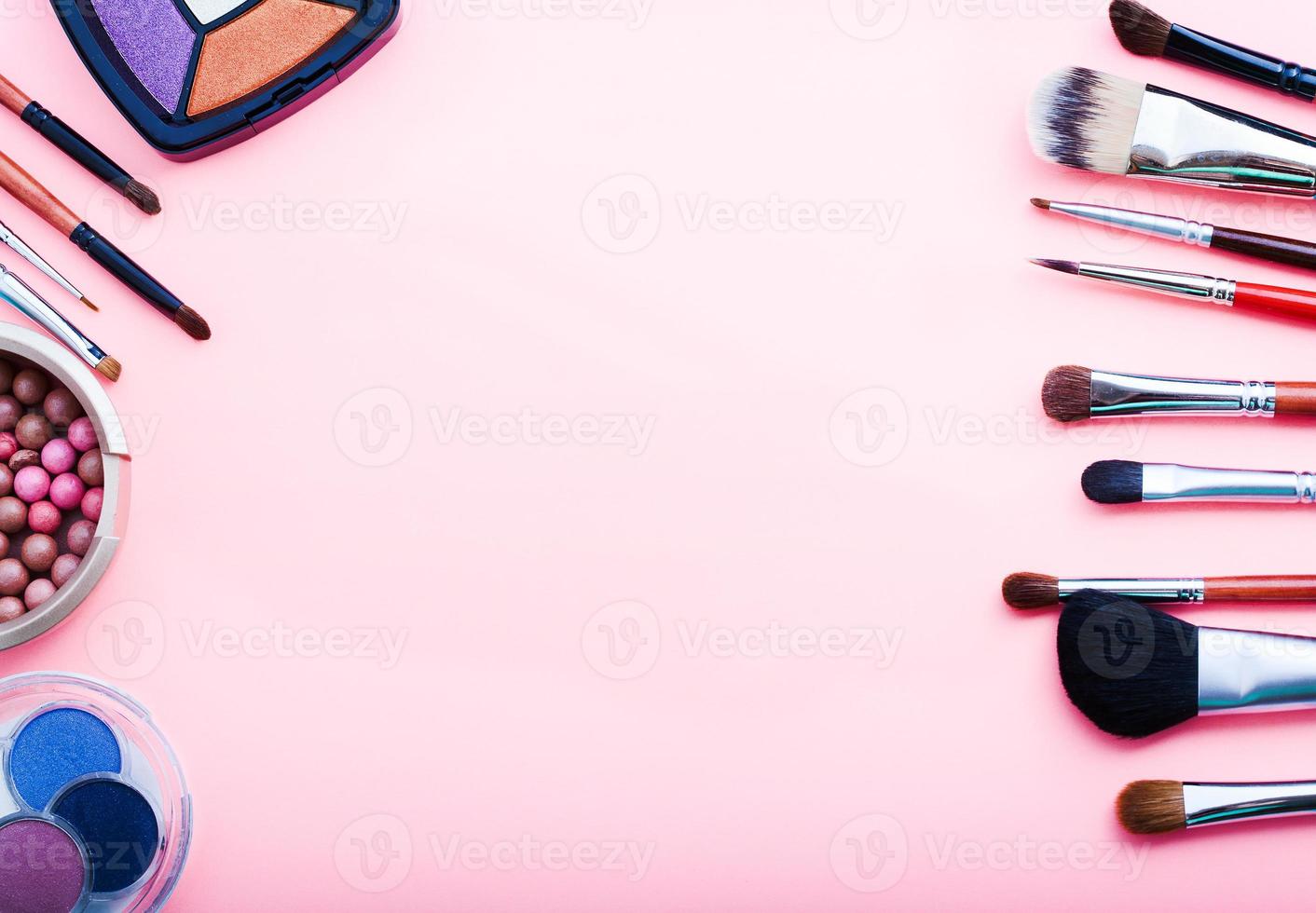 Frame of cosmetic accessories on pink background with copy space. Top view photo