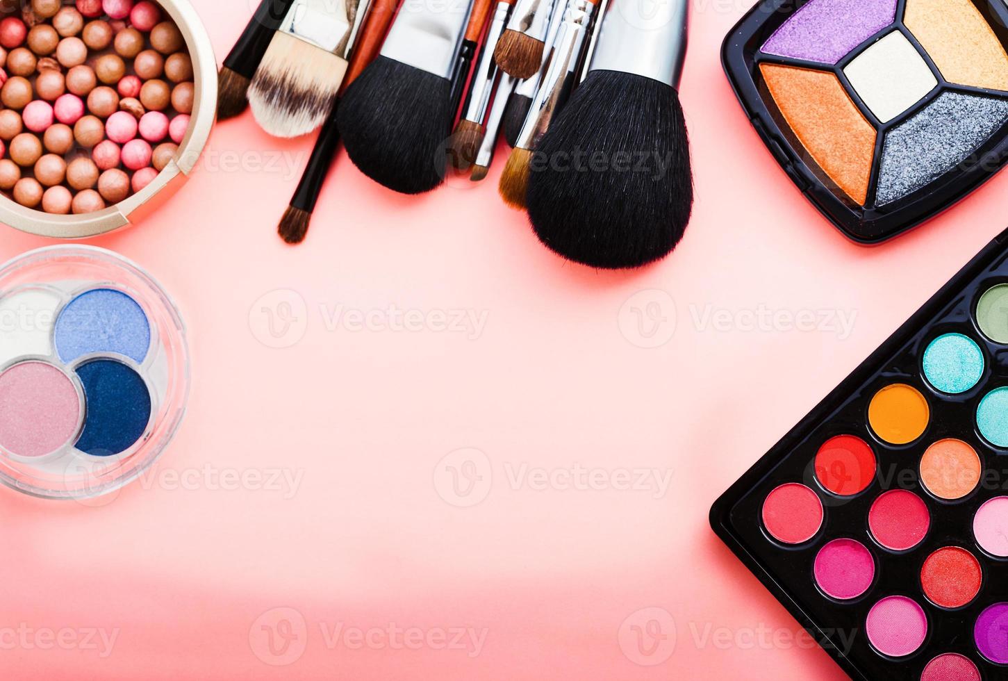 Frame of cosmetic accessories on pink background with copy space. Top view photo