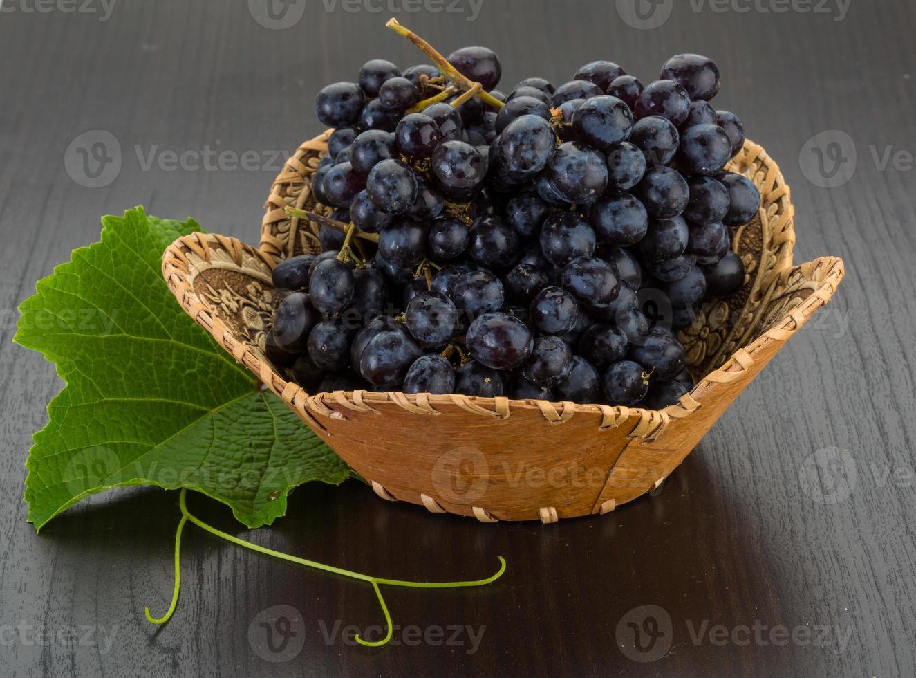 Grape in a basket on wooden background photo