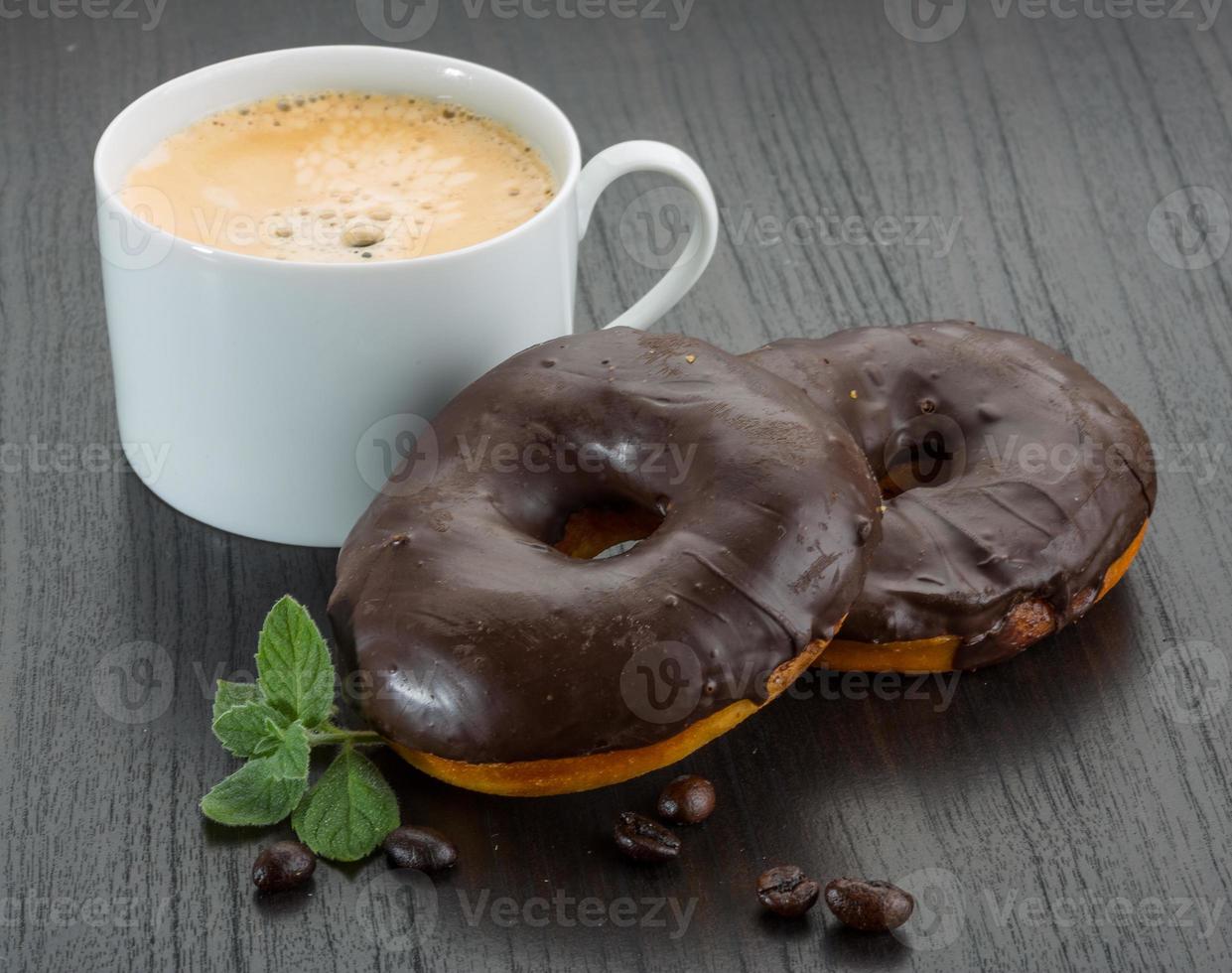 Coffee with Chocolate donuts on wooden background photo