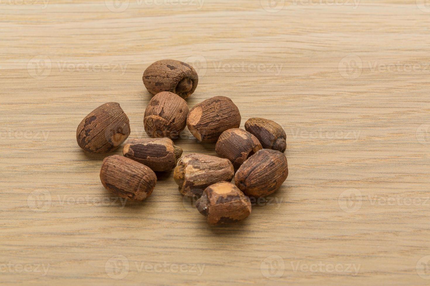 Small nutmeg on wooden background photo