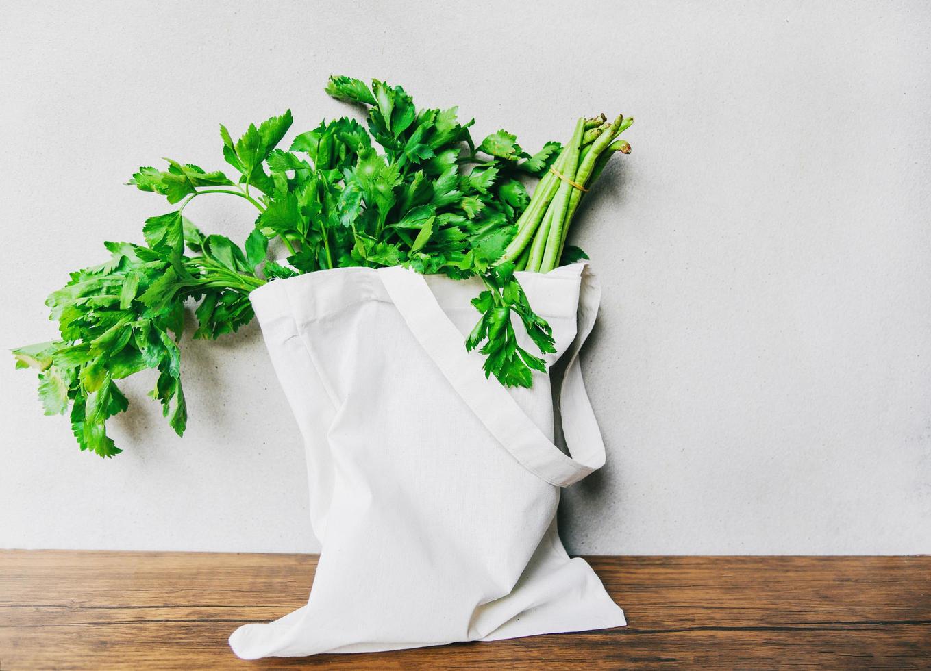 Zero waste use less plastic concept Fresh vegetables organic in eco cotton fabric bags on wooden table photo