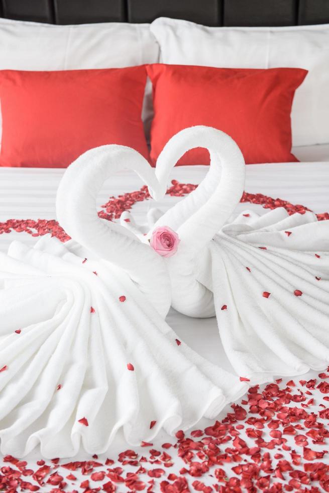 Two swans and heart made from towels on honeymoon bed photo