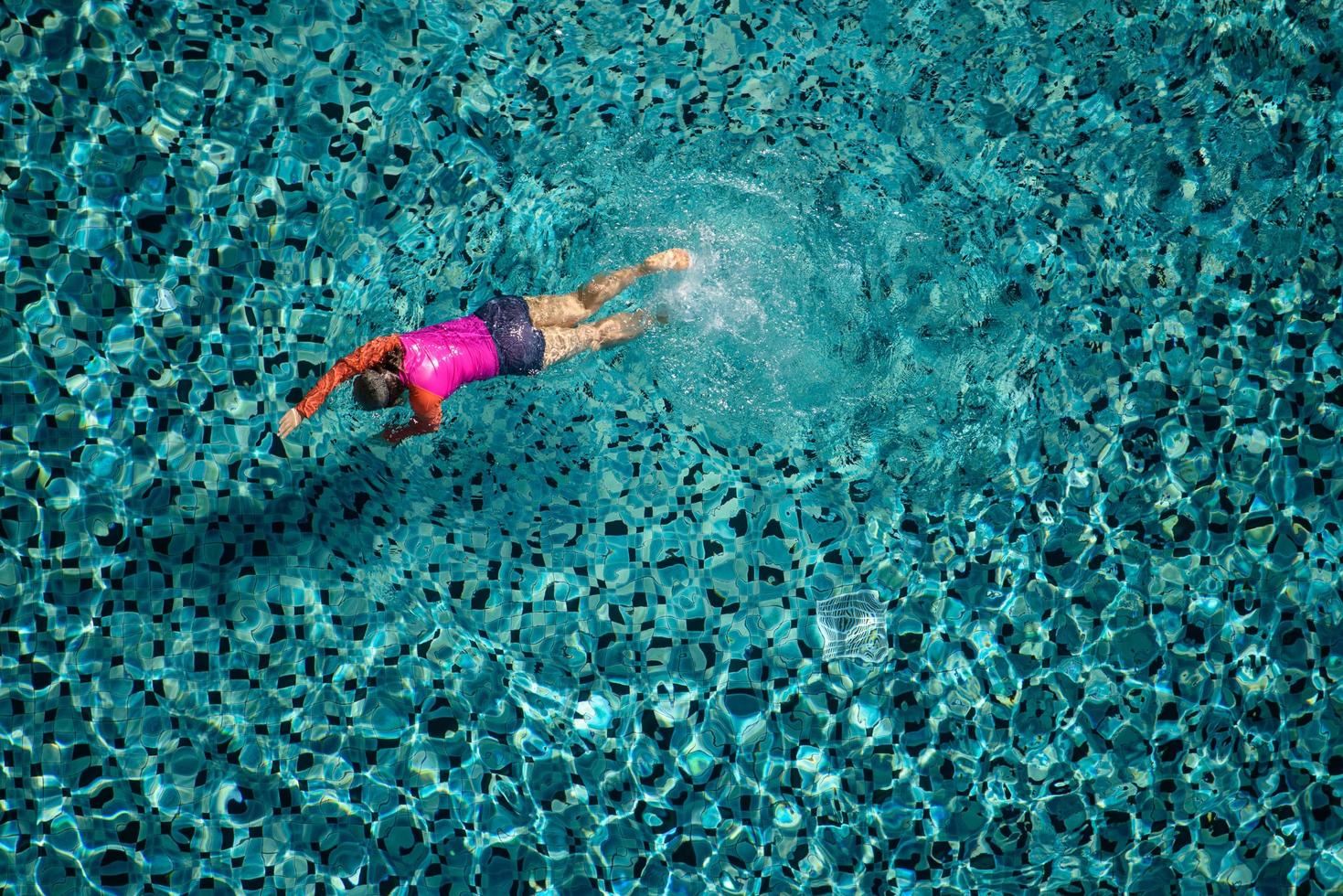 mujer nadar en la piscina del hotel. vista desde arriba. foto