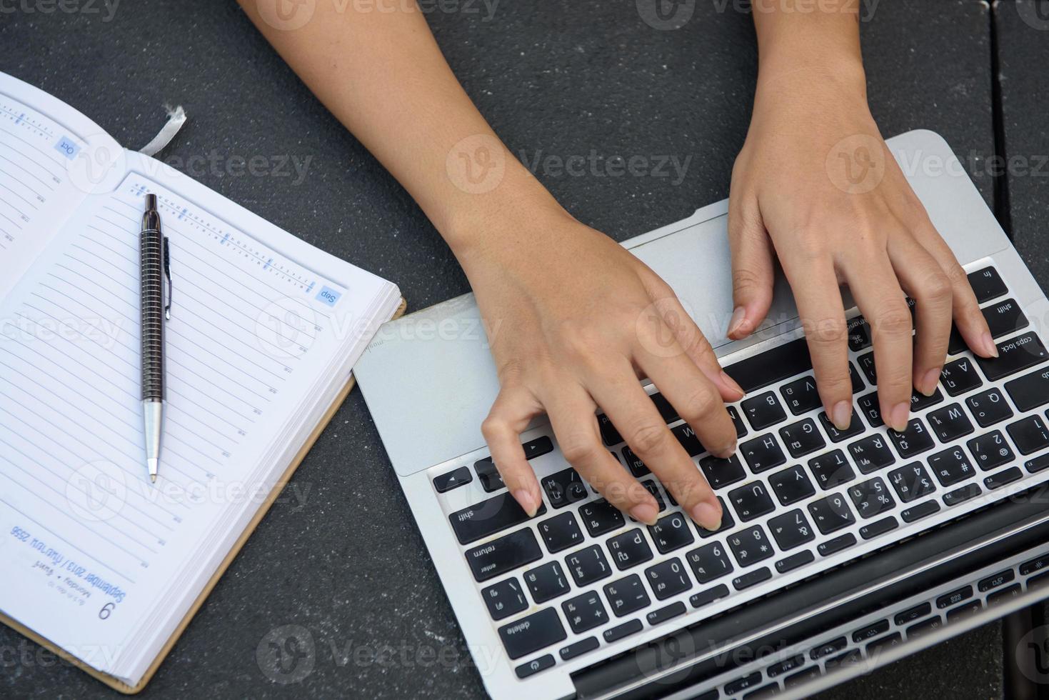 Woman working on laptop and writing, top view photo
