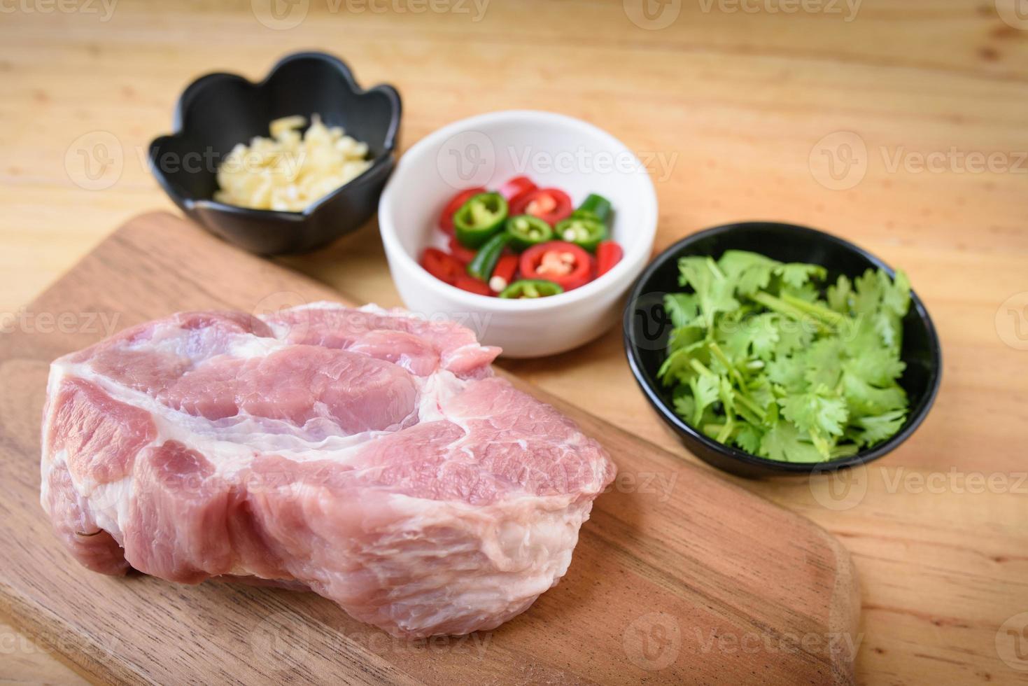 Raw pork on board and vegetables photo