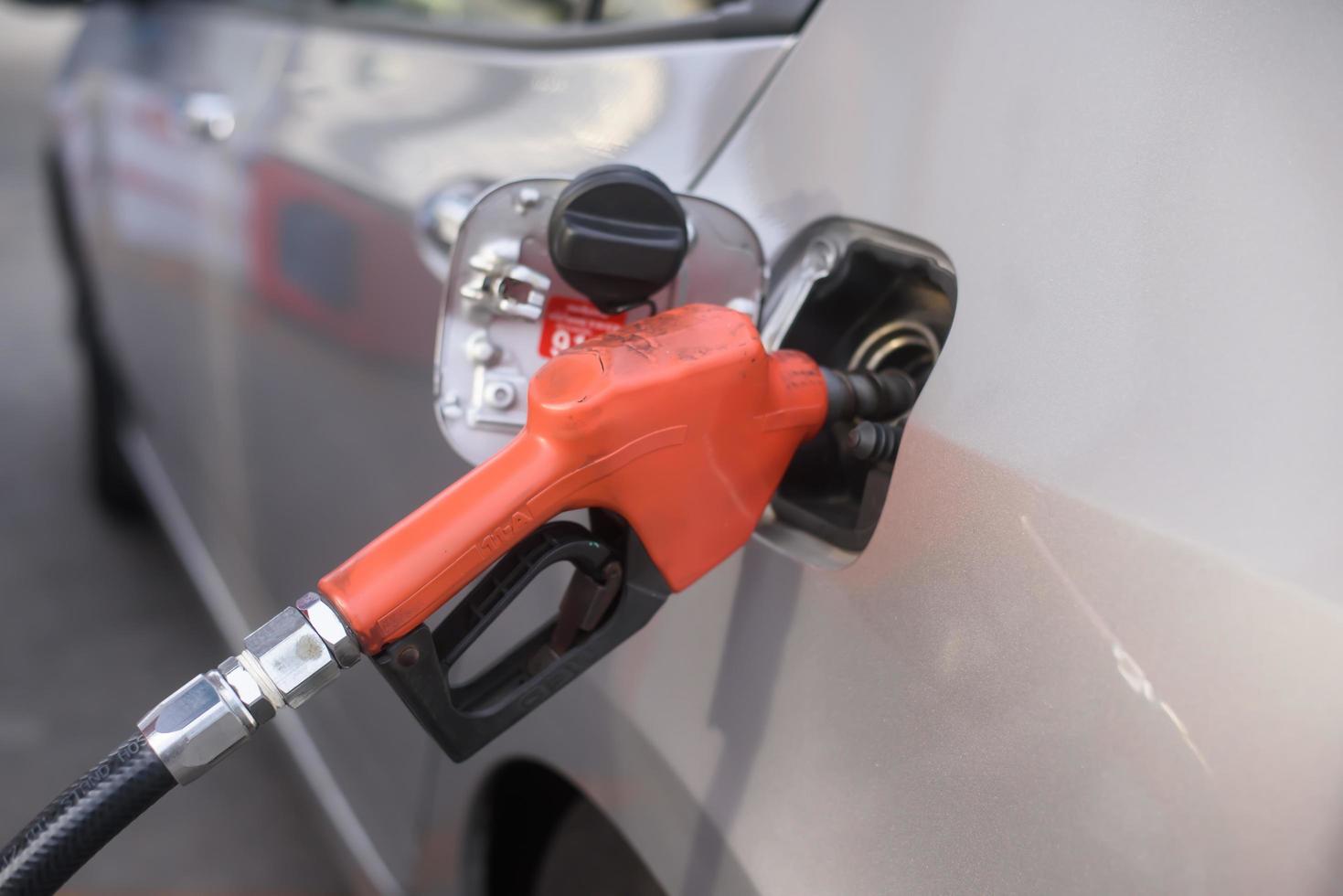 Boquilla de combustible durante el repostaje en una gasolinera. foto