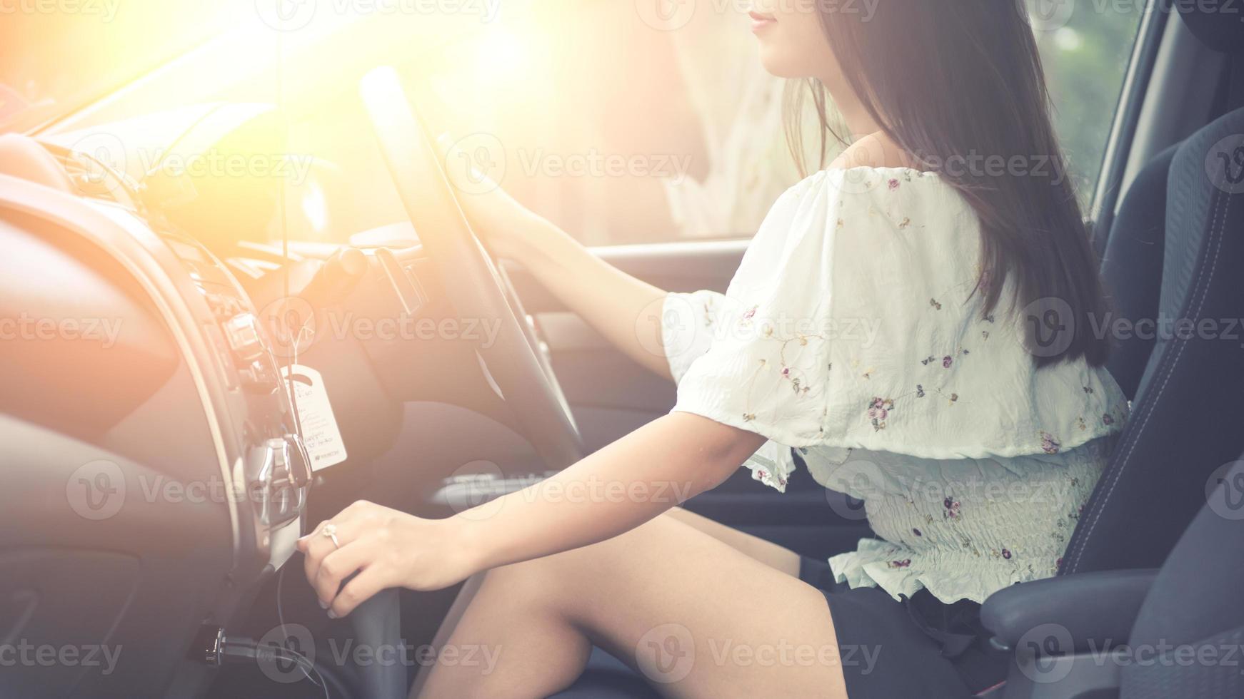 hermosa joven con una bonita sonrisa conduciendo un coche. vista trasera. foto