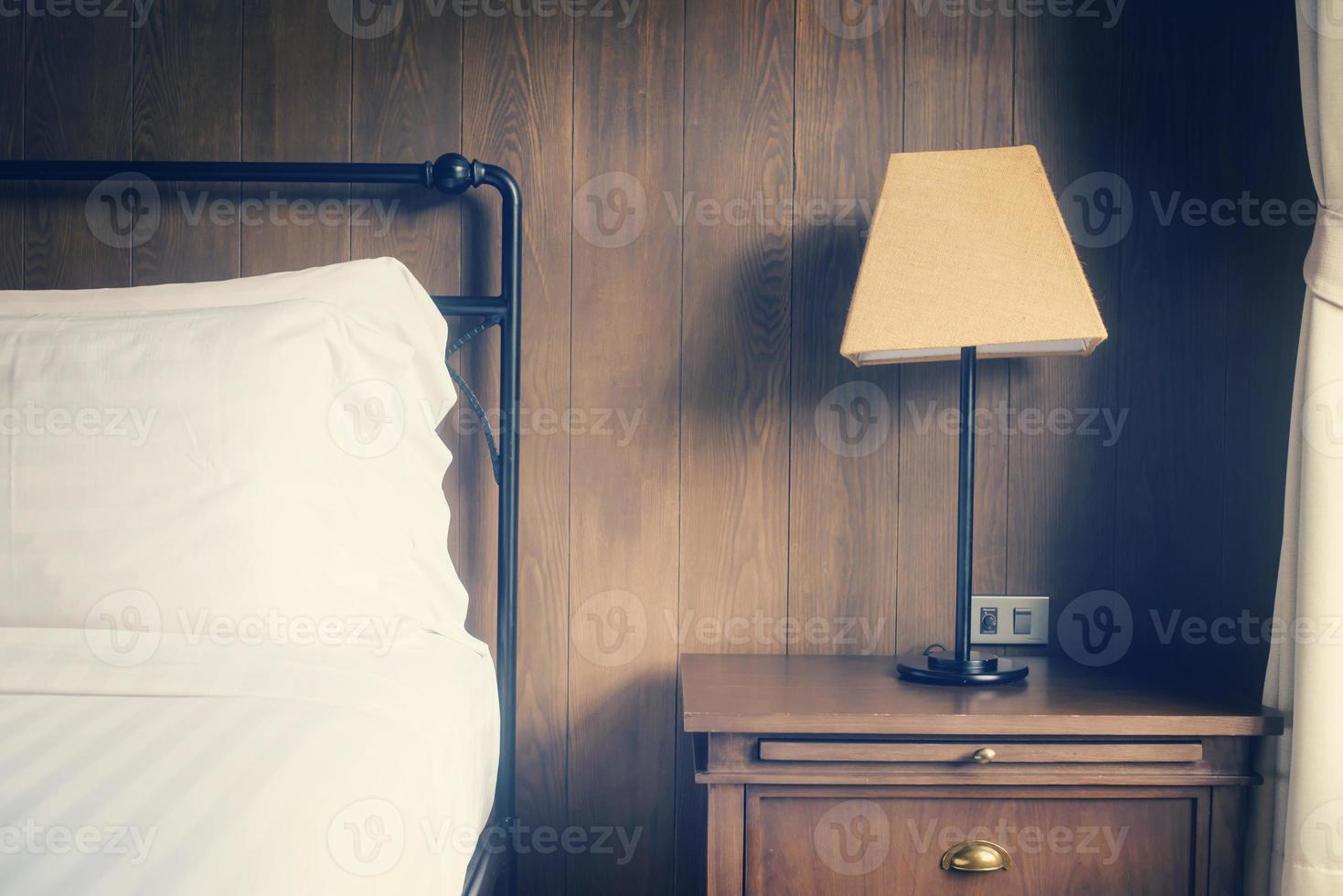 Abstract hotel bedroom with lamp and hotel bed with space for text photo
