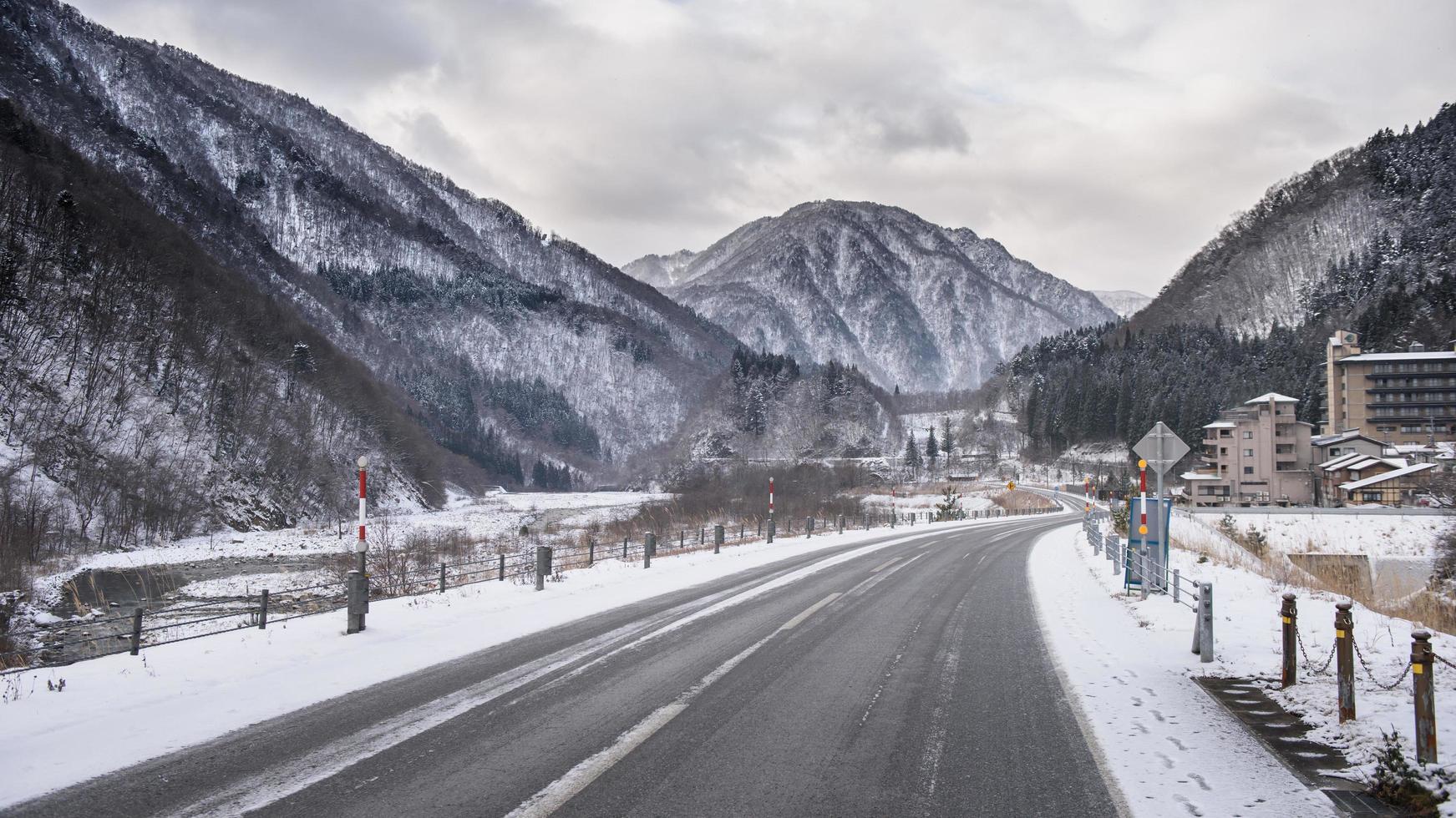 carretera cubierta de nieve vacía en el paisaje invernal foto