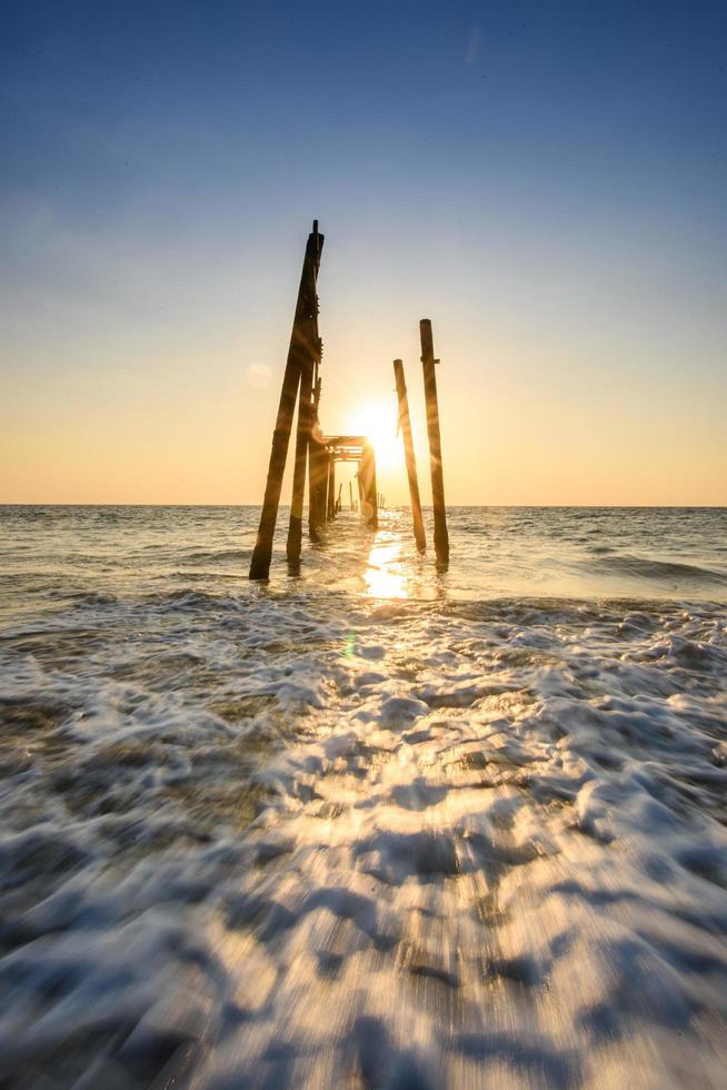 broken wooden bridge sunset on the sea at Phangnga, Thailand photo