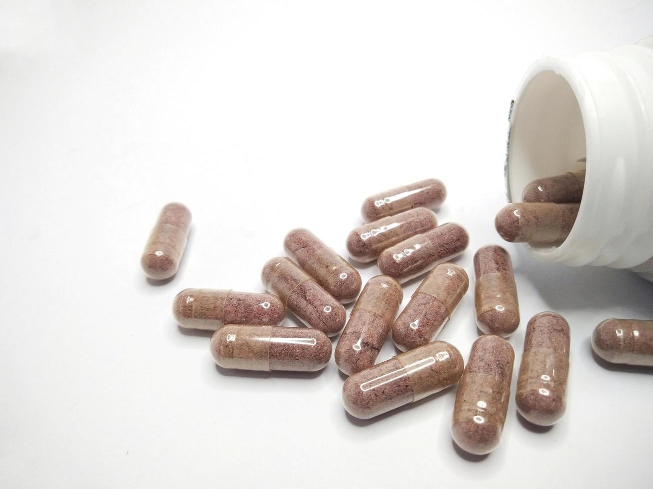 Cápsulas y frascos de medicamentos aislados en un fondo blanco foto