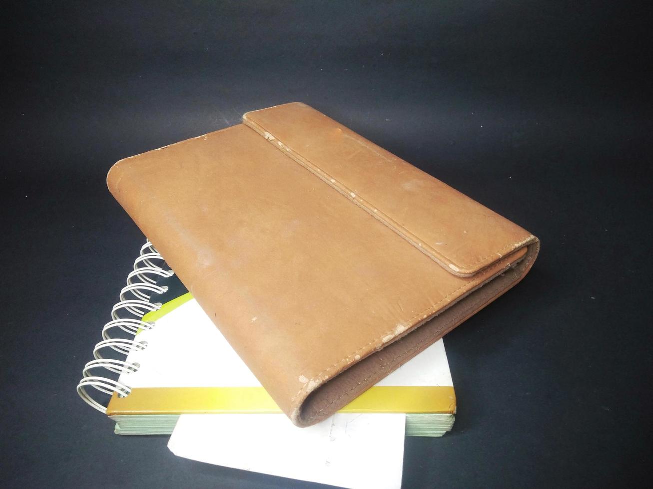 brown cover book on black background. painting light.close up. photo
