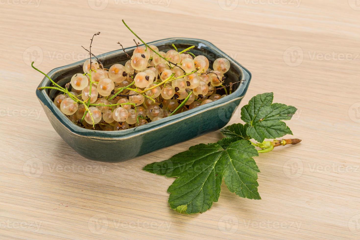 White currant in a bowl on wooden background photo
